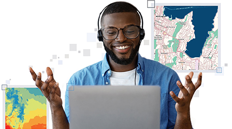 Eine lächelnde Person mit Headset an einem Laptop mit zwei verschiedenen Karten im Hintergrund