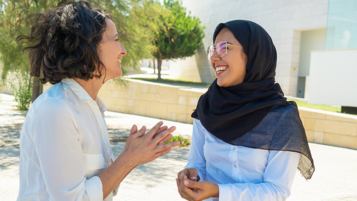 Zwei Frauen im Freien, die lachen und reden 