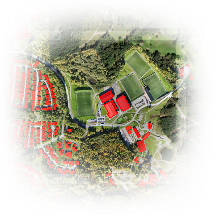 Satellitenbild einer Landfläche, auf der extrahierte Gebäude in Rot sowie grüner Boden und Bäume zu sehen sind