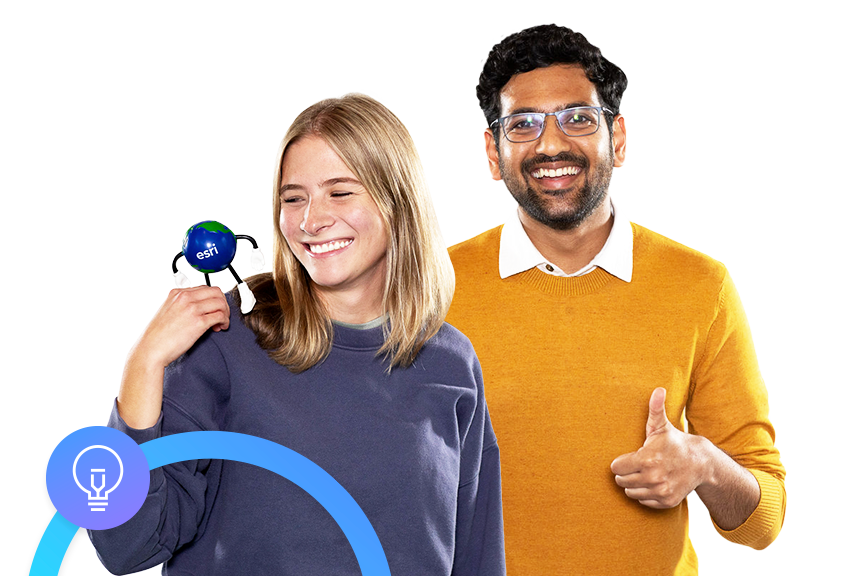 Zwei lächelnde Personen in bunten Sweatshirts, eine hält ein Globie-Maskottchen, die andere zeigt der Kamera den Daumen hoch 